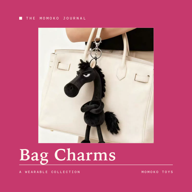 Black horse plush keychain charm hanging from a cream handbag